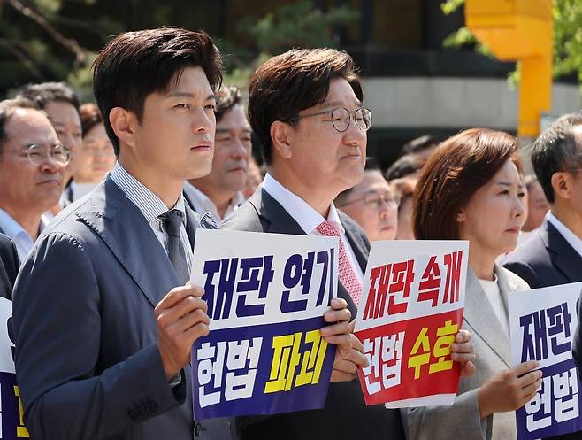 국민의힘 김용태 비상대책위원장과 권성동 원내대표가 11일 이재명 대통령의 공직선거법 위반 사건의 파기환송심을 사실상 무기한 연기한 서울고등법원 앞에서 열린 현장 의원총회에 참석해 있다. /연합뉴스