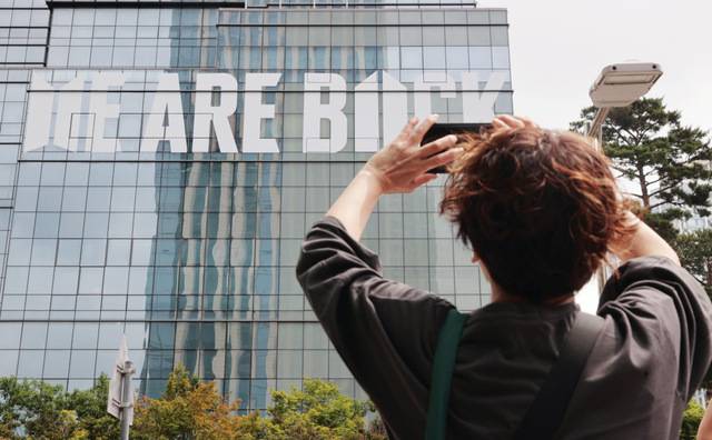 이날 서울 용산구 하이브 사옥 외벽에 이들의 전역을 기념해 '위 아 백(WE ARE BACK)'이라는 문구가 래핑된 모습이다. 연합뉴스