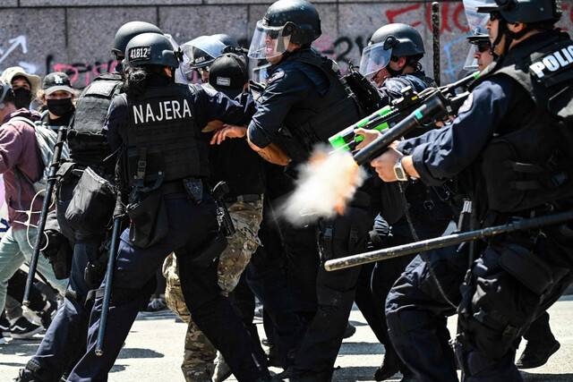비살상탄을 쏘며 시위 진압에 나선 경찰. LA 시위가 닷새째 이어진 가운데 도심 일부 지역에는 야간 통행금지령이 내려졌다. AFP연합뉴스
