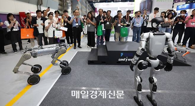 11일 서울 강남구 삼성동 코엑스에서 열린 ‘2025 스마트테크코리아’를 찾은 관람객들이 유니트리의 휴머노이드 로봇 ‘G1’과 사족보행 로봇을 살펴보고 있다.  2025.6.11 [한주형 기자]