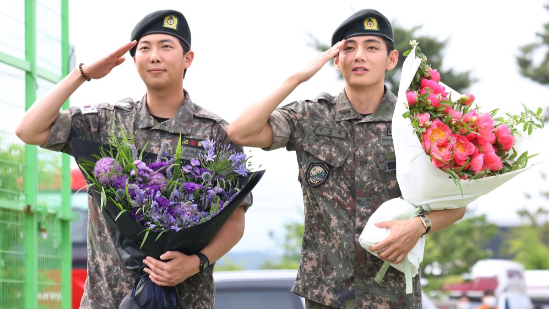 육군 현역 복무를 마치고 만기 전역한 그룹 방탄소년단(BTS) RM과 뷔가 6월 10일 강원 춘천시 신북읍체육공원에서 취재진을 향해 거수경례하고 있다. (사진=연합뉴스)