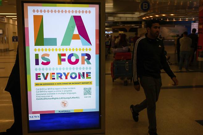 Travelers pass a sign that reads, “LA is for everyone,” in the international arrivals area at the Los Angeles International Airport in Los Angeles, Saturday, June 8, 2025. (AP Photo/William Liang)