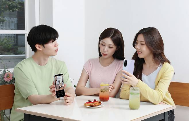 삼성전자 모델들이 ‘갤럭시 A36 5G’로 촬영한 사진을 ‘AI 지우개’ 기능으로 보정하는 모습. [삼성전자 제공]