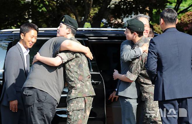 [연천=뉴시스] 김혜진 기자 = 군 복무를 마친 방탄소년단 지민, 정국이 11일 오전 경기도 연천군의 한 부대 인근에서 관계자와 포옹을 나누고 있다. 2025.06.11. jini@newsis.com