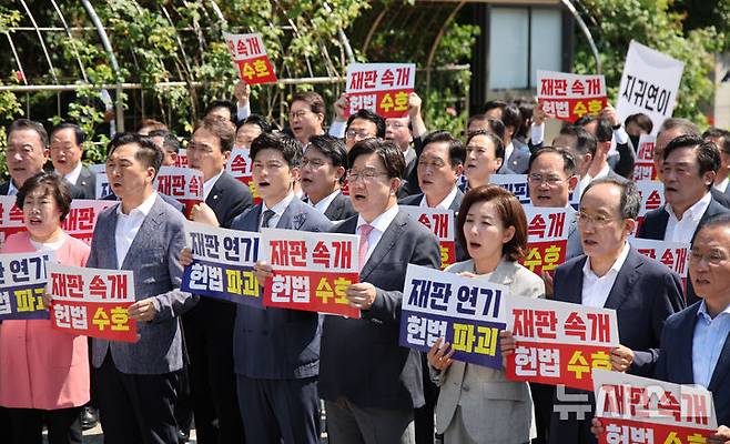 [서울=뉴시스] 김금보 기자 = 김용태 국민의힘 비상대책위원장과 권성동 원내대표 등 참석 의원들이 11일 오전 서울 서초구 서울고등법원에서 법원의 이재명 대통령 공직선거법 위반 파기환송심 기일 추후 지정 결정을 비판하는 현장의원총회를 열고 구호를 외치고 있다. 2025.06.11. kgb@newsis.com