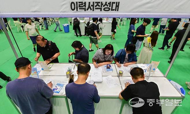 12일 오후 평택시 이충문화체육센터에서 열린 '2025년 상반기 평택시 일자리박람회'를 방문한 시민들이 이력서를 작성하고 있다. 임채운기자