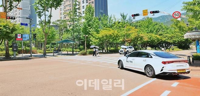 과천시 별양동 코오롱 삼거리에 설치된 과천형 스마트 보행자안전시스템이 우회전 차량에게 횡단보도 상황을 실시간 영상으로 보여주고 있다.(사진=과천시)
