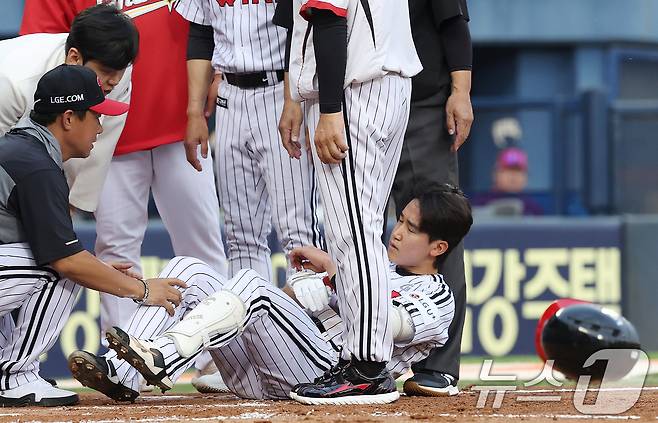12일 오후 서울 송파구 잠실야구장에서 열린 프로야구 '2025 신한 SOL뱅크 KBO 리그' SSG 랜더스와 LG 트윈스의 경기, 2회말 LG 선두타자 구본혁이 SSG 선발투수 전영준의 투구에 몸에 맞은 뒤 그라운드에 누워 헬멧을 내던지고 있다. 2025.6.12/뉴스1 ⓒ News1 이동해 기자