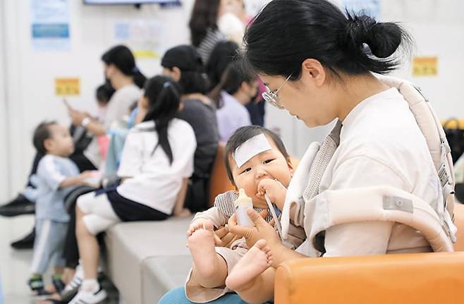 지난 10일 서울 구로구의 한 소아청소년과 병원에서 보호자와 아이들이 진료 차례를 기다리고 있다. 최근 부모들은 소아청소년과 병의원에서 국가 필수 검진인 영유아 건강검진을 받기 위해 예약 전쟁을 벌이고 있다. /장경식 기자