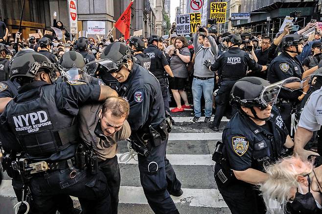 “이민 단속 말라” 美 LA 이어 뉴욕으로 번진 시위 - 지난 10일 미국 뉴욕의 한 연방정부 기관 건물 앞에서 도널드 트럼프 미국 대통령의 불법 이주자 단속 및 추방 정책에 반대하는 시위를 벌이던 사람들이 경찰에 연행되고 있다. 지난 6일 로스앤젤레스에서 시작된 시위는 샌프란시스코와 뉴욕, 시카고 등 미국의 다른 주요 대도시로 확산하고 있다. /AFP 연합뉴스