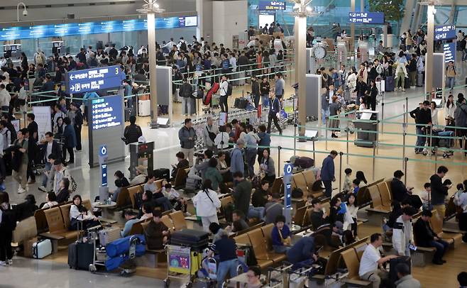 사진은 지난 5월 황금연휴를 앞둔 인천국제공항 제1여객터미널 출국장에서 승객들이 탑승 수속을 위해 줄을 서고 있는 모습. /연합뉴스