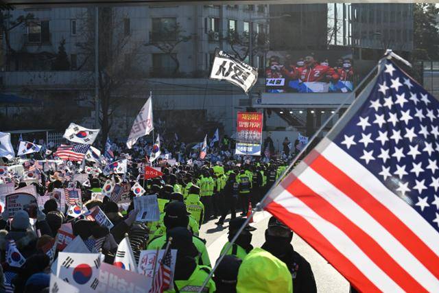 윤석열 대통령에 대한 체포영장 발부 나흘째인 1월 3일 서울 용산구 한남동 대통령 관저 정문 앞에서 보수 유튜버들이 태극기와 성조기를 들고 이동하고 있다. 코리아타임스