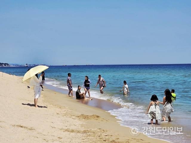 ▲ 12일 무더위를 피하기 위해 경포해변을 찾은 가족 단위 관광객들이 바닷가에서 더위를 식히고 있다. 황선우 기자