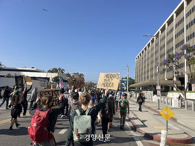 도널드 트럼프 미국 행정부의 이민자 단속에 항의하는 시위대가 10일(현지시간) 캘리포니아주 로스앤젤레스(LA) 도심의 연방기관 청사 앞을 행진하고 있다. 로스앤젤레스 | 김유진 특파원