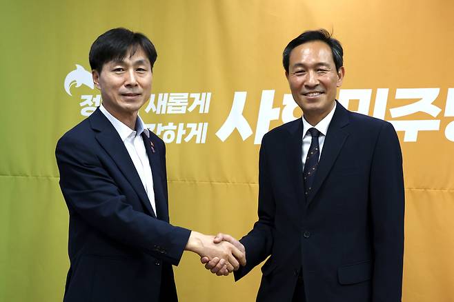우상호 대통령실 정무수석(오른쪽)이 12일 국회 의원회관에서 한창민 사회민주당 대표를 예방해 악수하고 있다. 사회민주당 제공