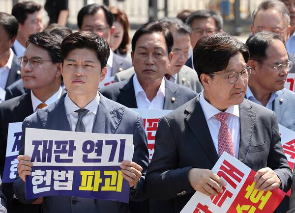 ▲국민의힘 김용태 비상대책위원장과 권성동 원내대표가 지난 11일 이재명 대통령의 공직선거법 위반 사건의 파기환송심을 사실상 무기한 연기한 서울고등법원 앞에서 열린 현장 의원총회를 마무리 하고 있다. ⓒ연합뉴스