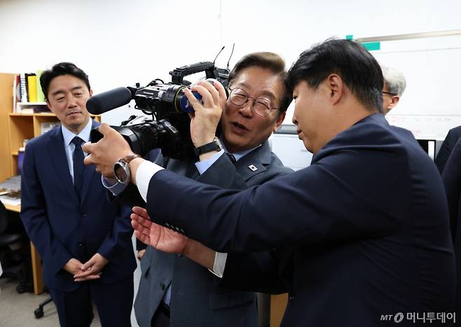 [서울=뉴시스] 최진석 기자 = 이재명 대통령이 12일 서울 용산 대통령실 영상기자실을 방문해 영상카메라를 들어 보이고 있다. 2025.06.12. myjs@newsis.com /사진=최진석