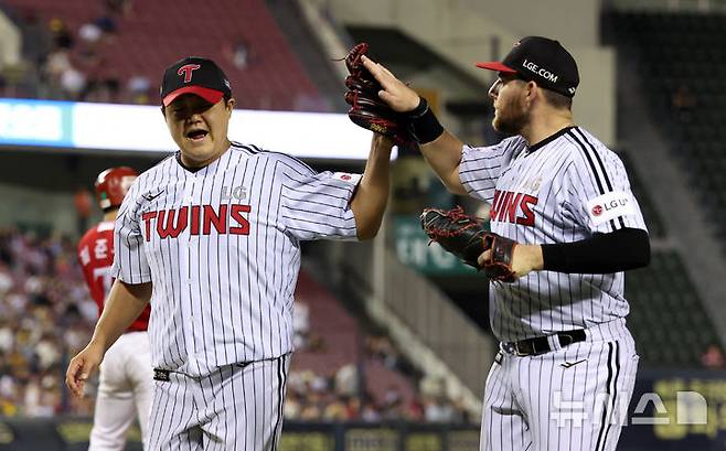 [서울=뉴시스] 김선웅 기자 = 11일 서울 송파구 잠실야구장에서 열린 2025 프로야구 SSG 랜더스와 LG 트윈스의 경기, 8회초 LG 교체투수 장현식이 투구를 마치고 더그아웃으로 복귀하며 오스틴과 하이파이브를 하고 있다. 2025.06.11. mangusta@newsis.com