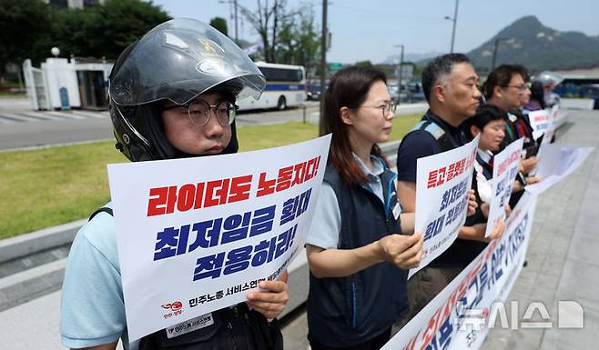 [서울=뉴시스] 김선웅 기자 = 민주노총 서비스연맹 배달플랫폼 노동조합원들이 지난 9일 서울 종로구 정부서울청사 앞에서 기자회견을 열고 배달노동자 최저임금 확대 적용을 촉구하고 있다. 2025.06.09. mangusta@newsis.com