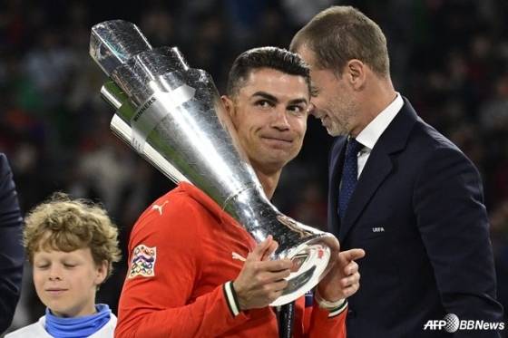 크리스티아누 호날두(가운데)가 독일 뮌헨의 알리안츠 아레나에서 열린 2024~2025시즌 유럽축구연맹(UEFA) 네이션스리그(NL) A 챔피언십 결승전에서 스페인을 꺾고 트로피를 들며 미소짓고 있다. /AFPBBNews=뉴스1