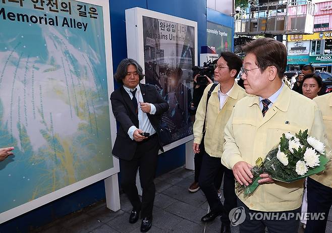 이재명 대통령, 이태원참사 현장 헌화 (서울=연합뉴스) 홍해인 기자 = 이재명 대통령이 12일 서울 용산구 이태원 참사 현장 '10·29 기억과 안전의 길'에서 헌화를 위해 이동하고 있다. 2025.6.12 hihong@yna.co.kr