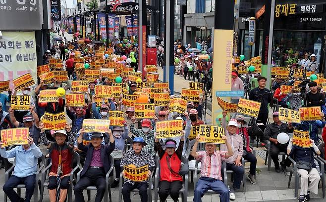 포항 촉발 지진 위자료 소송 시민 궐기대회가 13일 오후 포항시 북구 중앙상가 실개천 거리에서 열렸다. 참가 시민들이 재판부를 규탄하는 구호를 외치고 있다. /이용선기자 photokid@kbmaeil.com