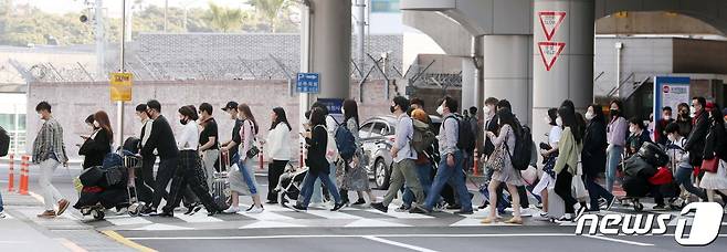 제주공항에서 제주에 입도한 관광객들이 횡단보도를 건너고 있다. /뉴스1 ⓒ News1 오현지 기자