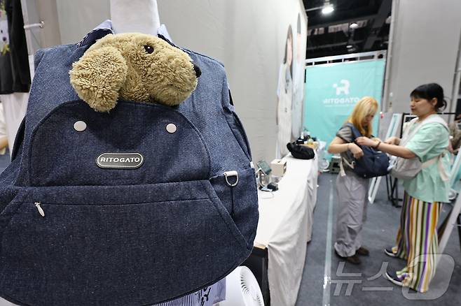 13일 서울 강서구 코엑스 마곡에서 열린 '2025 케이펫페어'에서 관람객들이 반려동물 포대기를 살펴보고 있다. 2025.6.13/뉴스1 ⓒ News1 김도우 기자