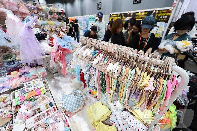 13일 서울 강서구 코엑스 마곡에서 열린 '2025 케이펫페어'에서 관람객들이 반려동물 옷을 살펴보고 있다. 2025.6.13/뉴스1 ⓒ News1 김도우 기자