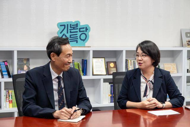 우상호(왼쪽) 대통령실 정무수석이 12일 국회 의원회관에서 용혜인 기본소득당 의원과 대화를 나누고 있다. 기본소득당 제공