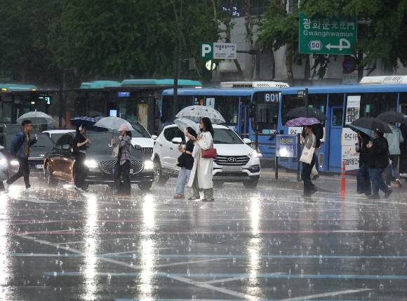 서울 광화문사거리에서 시민들이 우산을 쓴 채 횡단보도를 건너고 있다. 13일부터 제주도를 중심으로 많은 비가 내릴 것으로 예보됐다. [사진=연합뉴스]