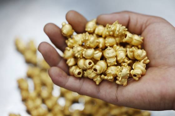 한국표준금거래소 양주공장에서 작업자가 연마 작업을 위해 금 상품을 옮기고 있는 모습. 연합뉴스