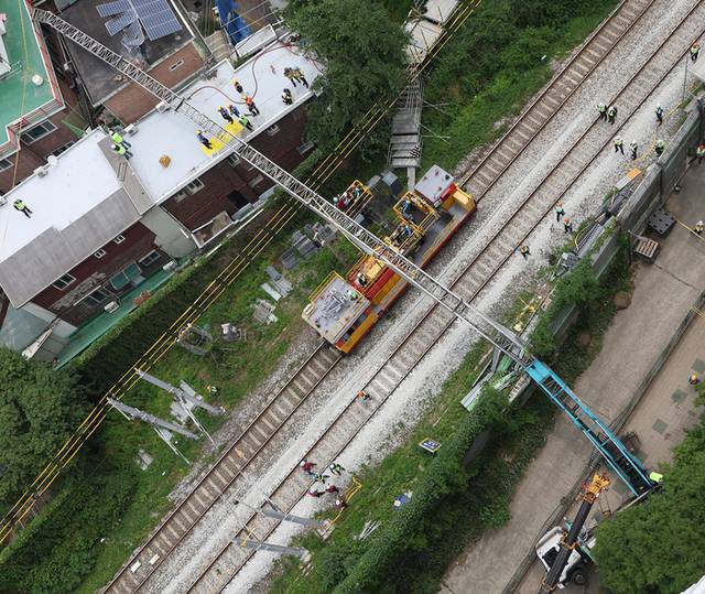 ▲ 13일 서울 서대문구 경의중앙선 가좌역∼신촌역 구간 선로 위로 사다리차가 넘어져 관계자들이 복구 작업을 하고 있다. 이 사고로 전기공급 장애가 발생, 열차 운행이 지연됐다. 연합뉴스
