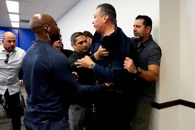 알렉스 파딜랴 미국 상원의원이 12일(현지시간) 캘리포니아주 로스앤젤레스 연방정부 청사에서 열린 크리스티 놈 국토안보장관 기자회견장에 들어가 질문을 던졌다가 연단에서 제지당하고 있다. 로이터연합뉴스