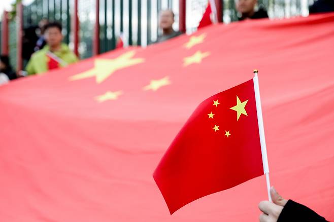 A person holds a Chinese flag outside a hotel where Chinese President Xi Jinping was staying in Moscow on May 7. [TASS/YONHAP]