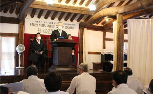 한복을 입은 문성모 목사가 2022년 10월 6일 전북 김제 금산교회에서 열린 ‘제8회 이자익 목회자상 수상식’에서 100년 전 예식대로 남녀 사이에 휘장을 치고 옛날 찬송가를 부르며 예배드리고 있다. 문 목사 제공