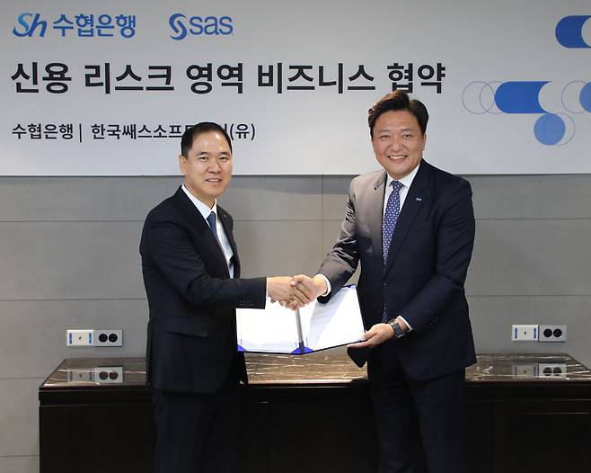 Sh수협은행이 데이터·인공지능(AI) 분야 기업인 SAS와 AI 기반 신용리스크 솔루션 공급과 아시아 시장 공략을 위한 마케팅 협력에 나선다. 신학기 수협은행장(왼쪽)과 이중혁 SAS코리아 대표가 협약 체결 후 기념촬영을 하고 있다.  Sh수협은행