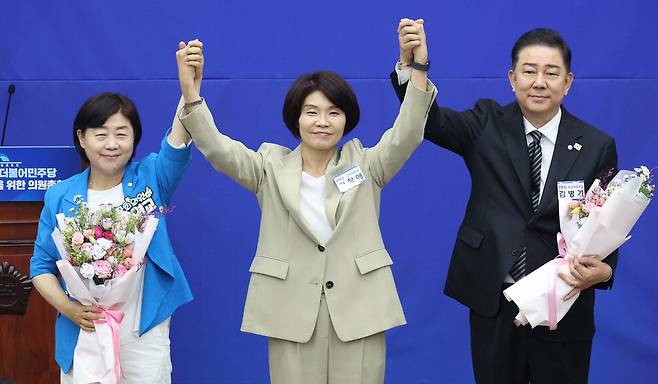 13일 더불어민주당 원내대표로 선출된 김병기 의원이 선거관리위원장을 맡은 한정애 의원, 원내대표를 두고 경쟁했던 서영교 의원(오른쪽부터)과 함께 손을 들어 올리고 있다.  한주형 기자