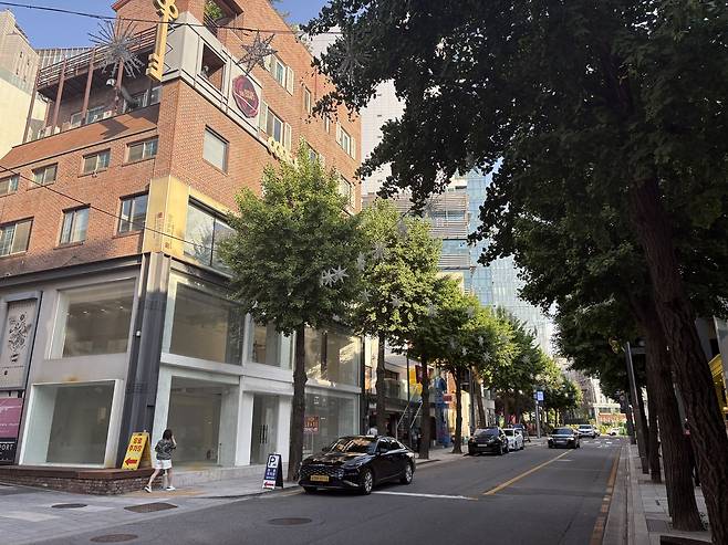 공실인 건물 앞으로 한 보행자가 지나가는 모습. 거리도 주정차 돼 있는 일부 차량을 제외하고 휑한 모습이다. [정주원 기자]