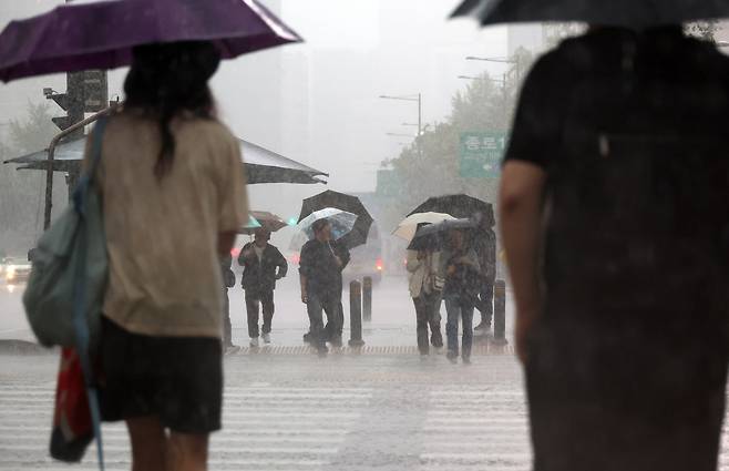 비가 내린 지난 5월 16일 서울 광화문사거리에서 시민들이 우산을 쓴 채 횡단보도를 건너기 위해 기다리고 있다. [연합]