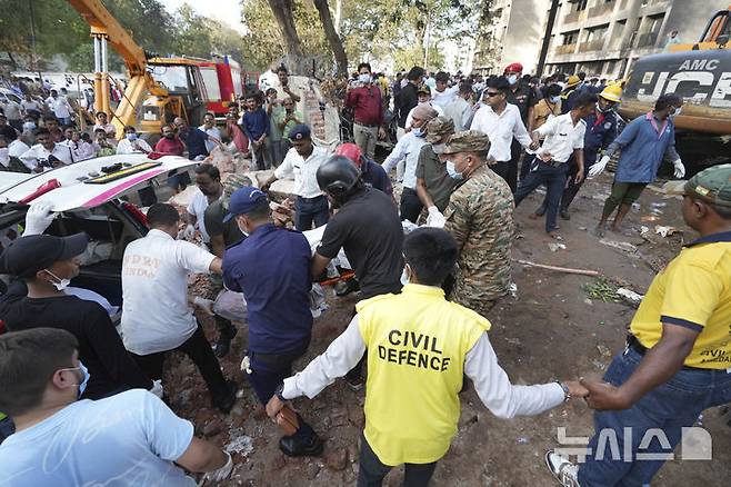 [아마다바드=AP/뉴시스] 12일(현지 시간) 인도 구자라트주 아마다바드 여객기 추락 현장에서 구조대가 희생자 시신을 옮기고 있다. 이날 아마다바드 공항에서 이륙한 영국행 에어인디아 AI171편 여객기가 추락해 탑승자 242명 가운데 1명을 제외한 전원이 숨졌으며, 추락 현장의 학생 등 약 50명도 사망한 것으로 전해졌다. 2025.06.13.