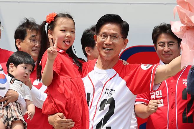 국민의힘 김문수 당시 대선 후보가 지난달 29일 인천 부평구 부평문화의거리에서 열린 유세에서 어린이를 안고 꽃다발을 흔들며 인사하고 있다. 연합뉴스