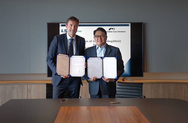 구자균(오른쪽) LS일렉트릭 회장과 데이비드 살보 파워일렉트로닉스 최고경영자(CEO)가 스페인 발레시아 파워일렉트로닉스 본사에서 글로벌 에너지저장장치(ESS) 전용 변압기 등 전력기기 공급 협력에 관한 양해각서(MOU)를 체결하고 기념 촬영을 하고 있다./사진=LS일렉트릭