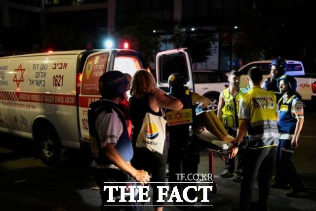 13일(현지 시간) 이스라엘 텔아비브에서 구급대원들이 이란이 발사한 미사일에 맞은 건물에서 부상자를 대피시키고 있다. /텔아비브=AP.뉴시스