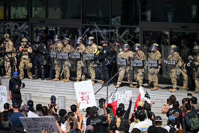 LA 도심에서 시민들이 트럼프 정부의 반이민 정책 시위를 벌이는 가운데 주방위군이 이를 저지하고 있다. 사진=연합뉴스