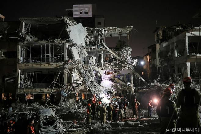 (라맛간 로이터=뉴스1) 류정민 특파원 = 13일(현지시간) 이란의 미사일 반격으로 파괴된 이스라엘 라맛간의 건물 잔해에서 요원들이 구조 작업 활동을 벌이고 있다. 2025.06.13  ⓒ 로이터=뉴스1  Copyright (C) 뉴스1. All rights reserved. 무단 전재 및 재배포,  AI학습 이용 금지. /사진=(라맛간 로이터=뉴스1) 류정민 특파원