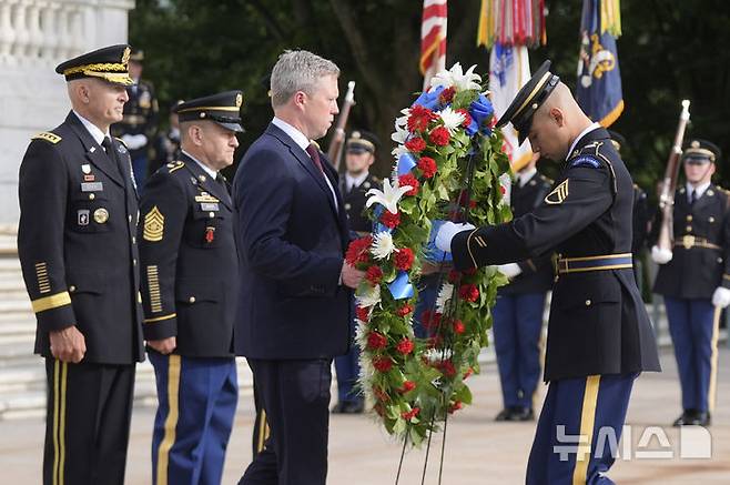 [버니지아=AP/뉴시스] 14일(현지 시간) NBC보도에 따르면 서베이몽키와 함께 진행한 여론 조사 결과, 미국 성인 중 64%가 군사 퍼레이드에 정부 예산을 사용하는 것을 반대했다. 정당별로는 민주당 지지자의 88%, 무당층의 72%가 반대 의견을 냈고, 공화당 지지자의 경우 65%가 찬성 입장을 보였다. 사진은 버지니아주 알링턴에서 도널드 트럼프 대통령의 79번째 생일과 동시에 맞은 미 육군 창설 250주년을 기념해, 대니얼 드리스콜 육군 장관이 알링턴 국립묘지의 무명용사의 묘에 헌화하고 있다.
