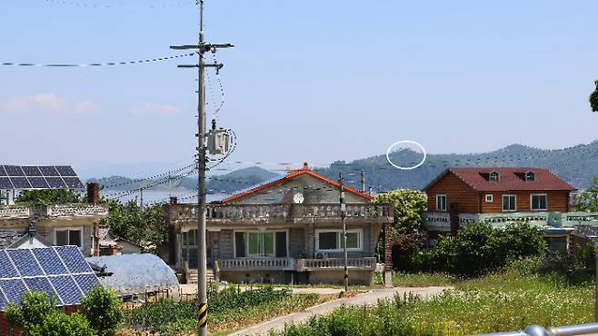 북한이 우리 군의 대북 확성기 방송 중지에 호응해 대남 소음 방송을 멈춘 것으로 추측되는 가운데 12일 인천 강화군 송해면 당산리 마을에서 바라본 북한 지역 야산에 대남 방송 스피커(흰색 원 안)가 보이고 있다. 연합뉴스