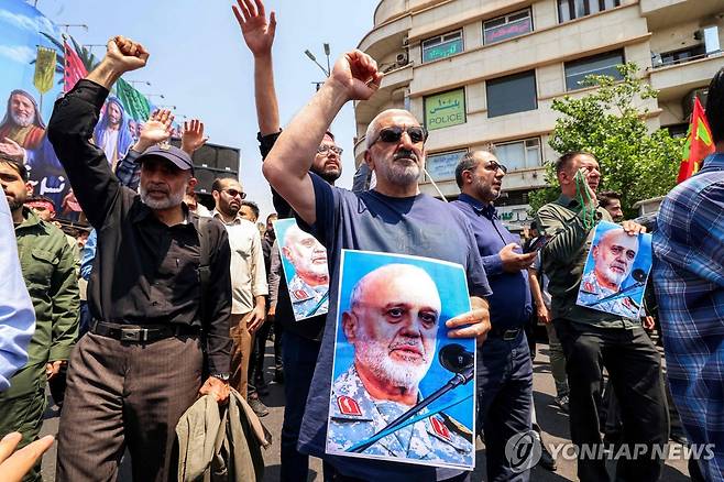 사망한 이란혁명수비대 사령관 사진 들고 있는 이란 시위대 (테헤란 AFP=연합뉴스) 13일(현지시간) 이란 수도 테헤란에서 시위대가 이스라엘의 공격을 규탄하는 시위를 벌이고 있다. 2025.06.14