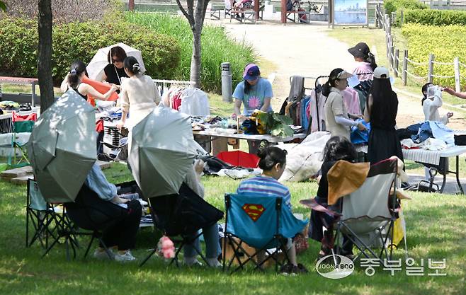 2025 송도굿마켓 행사에서 한 가족이 햇빛을 피해 그늘에서 휴식을 취하고 있다.정선식기자